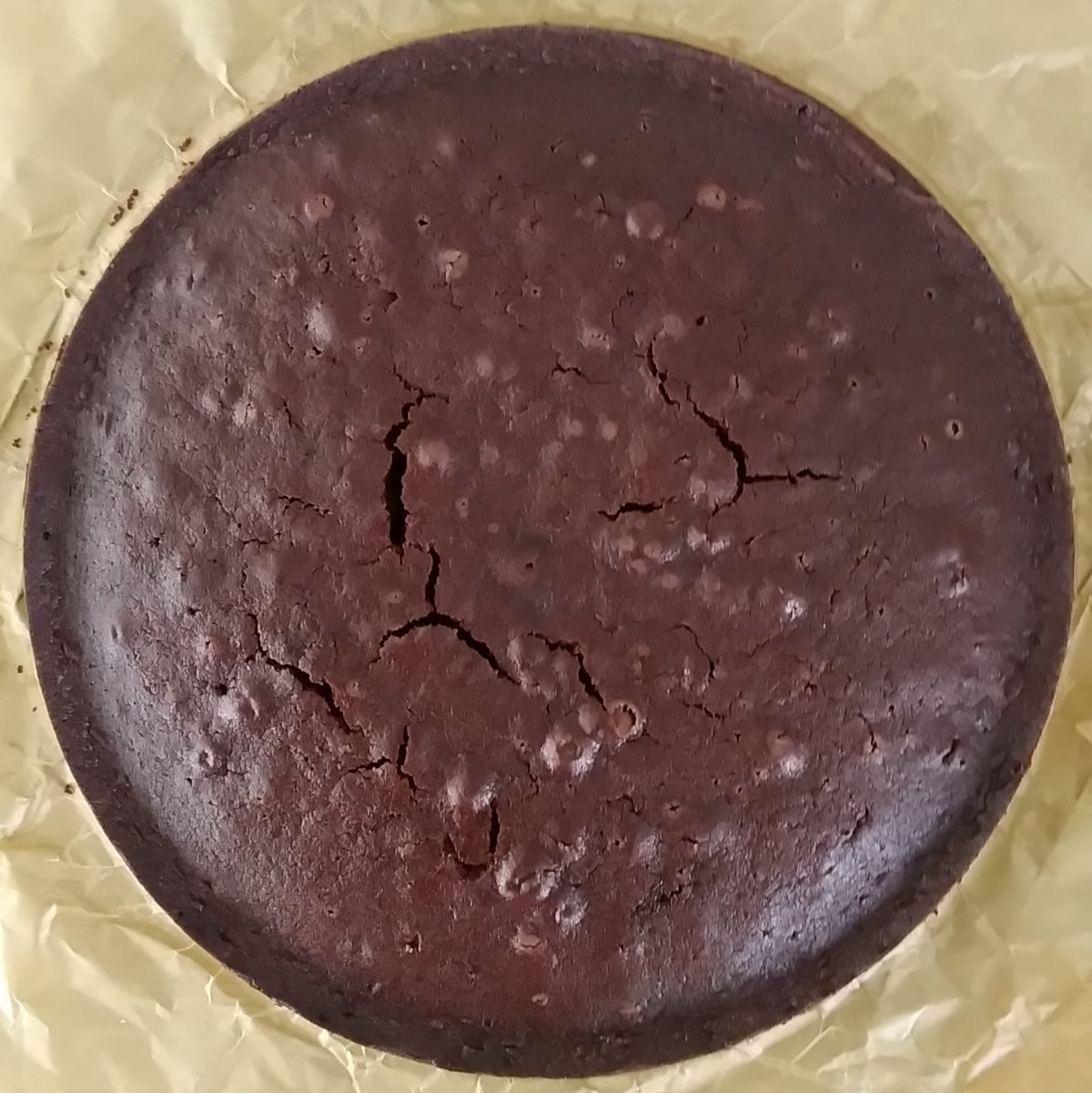 Bolo de chocolate redondo com a superfície rachada visto de cima