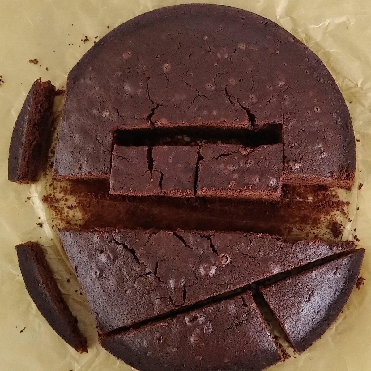 Bolo de chocolate rachado e quebrado em pedaços sobre papel-manteiga