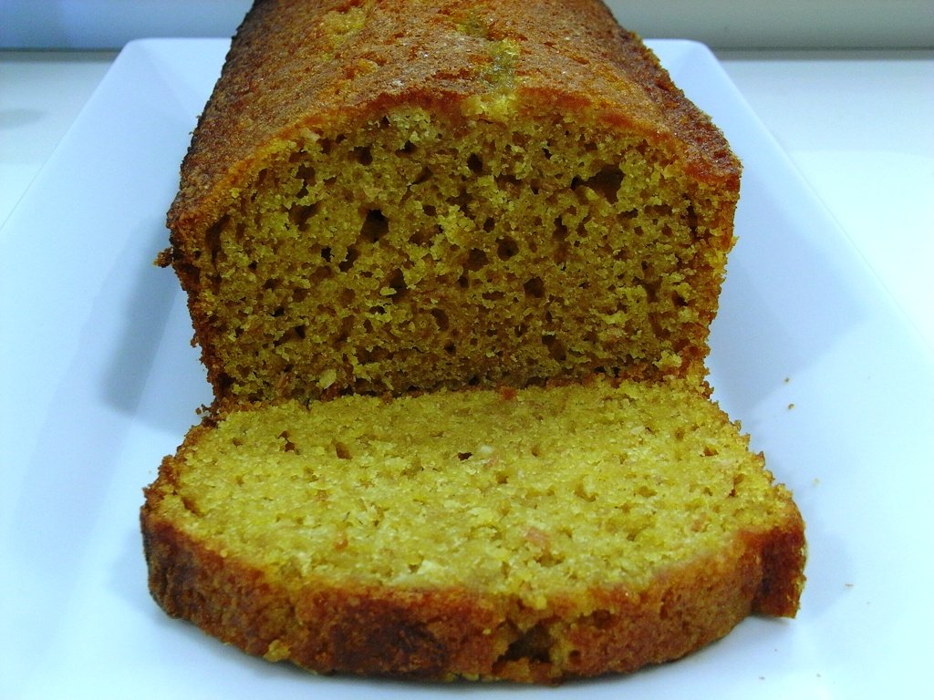 Bolo de abóbora alaranjado em formato de pão com uma fatia cortada