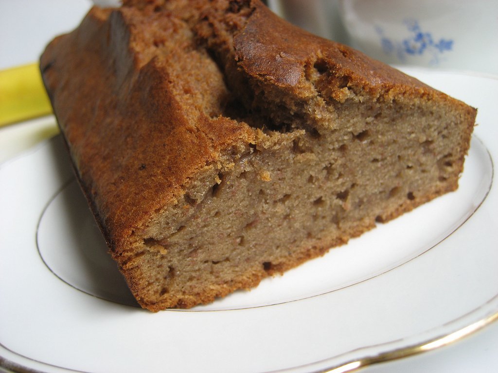 Bolo de banana caseiro em formato de pão cortado sobre prato branco