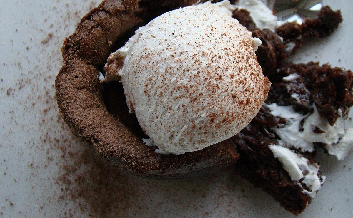 Bolinho de chocolate individual e úmido com bola de creme e cacau por cima