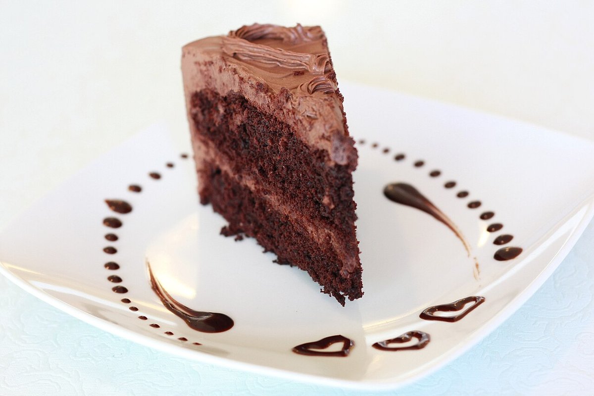 Fatia de bolo de chocolate em camadas com cobertura cremosa de chocolate