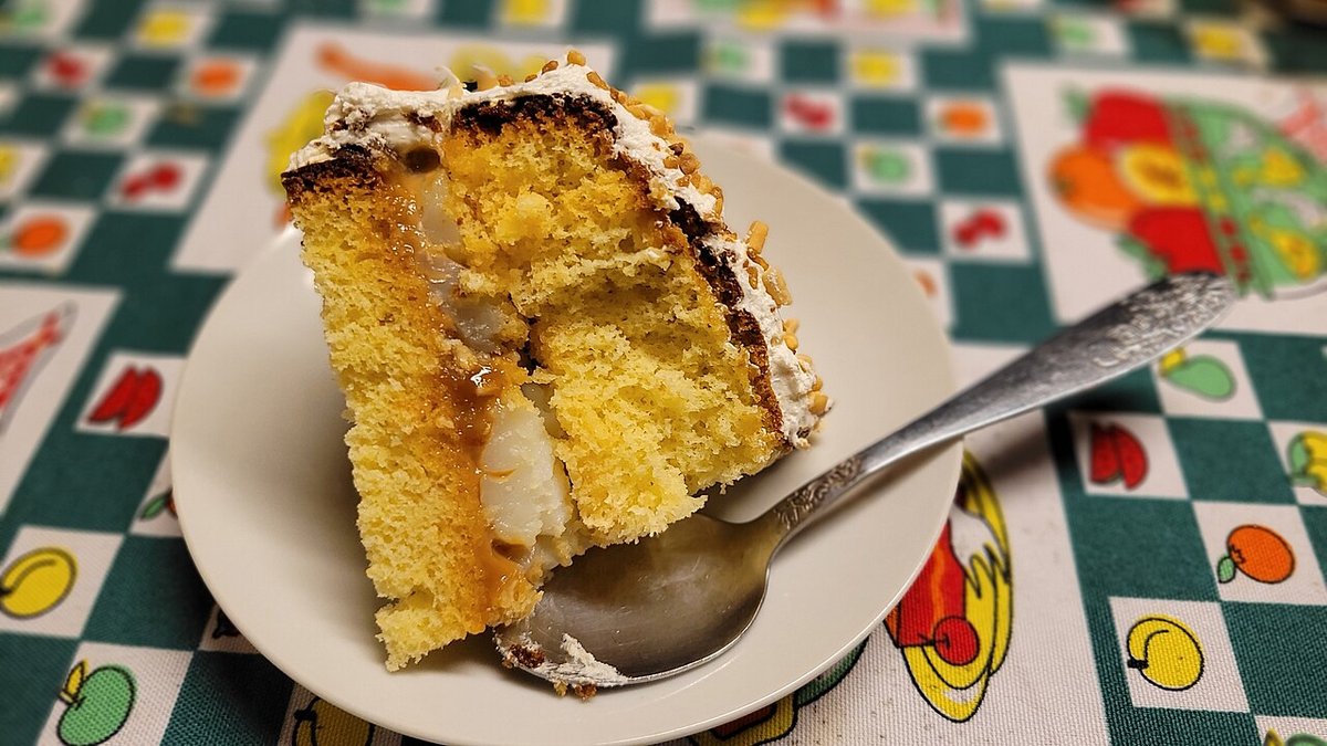 Fatia de bolo amarelo recheado com doce de leite e creme em prato