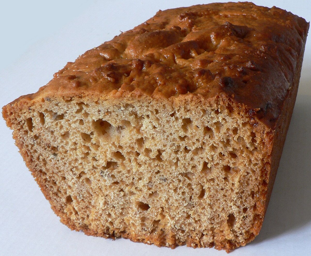 Bolo de especiarias escuro e aerado cortado ao meio, mostrando o miolo