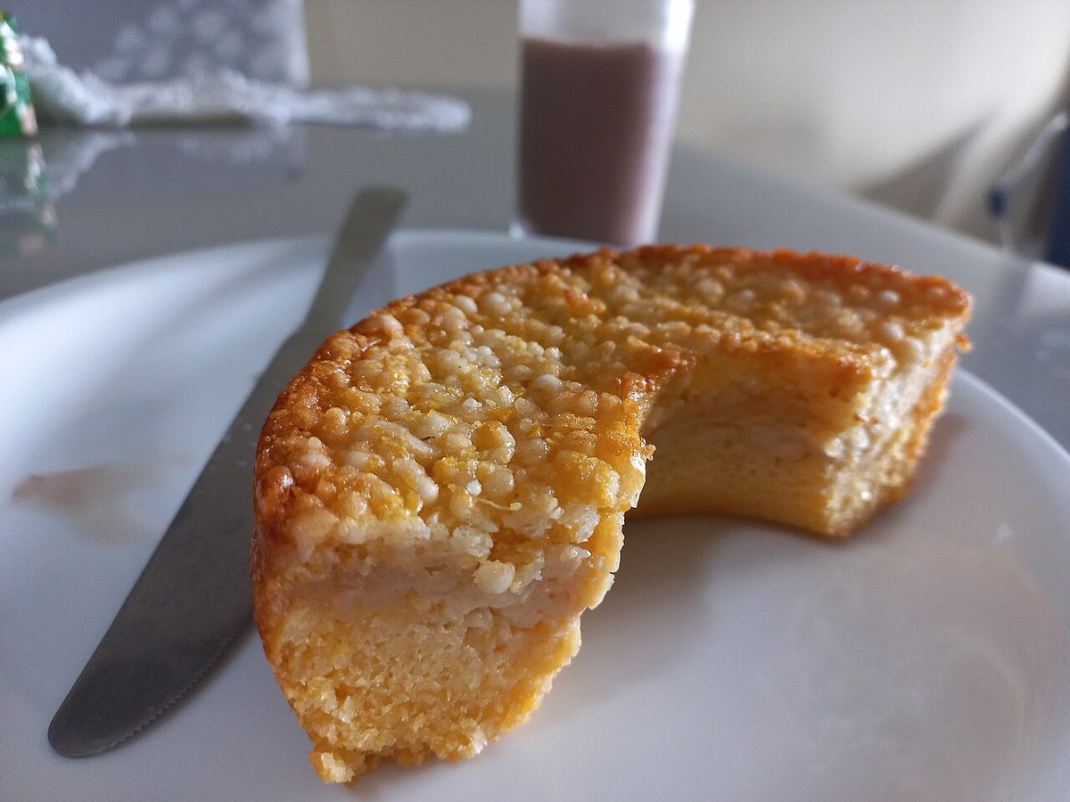 Pedaço de bolo de milho cremoso dourado servido em prato branco
