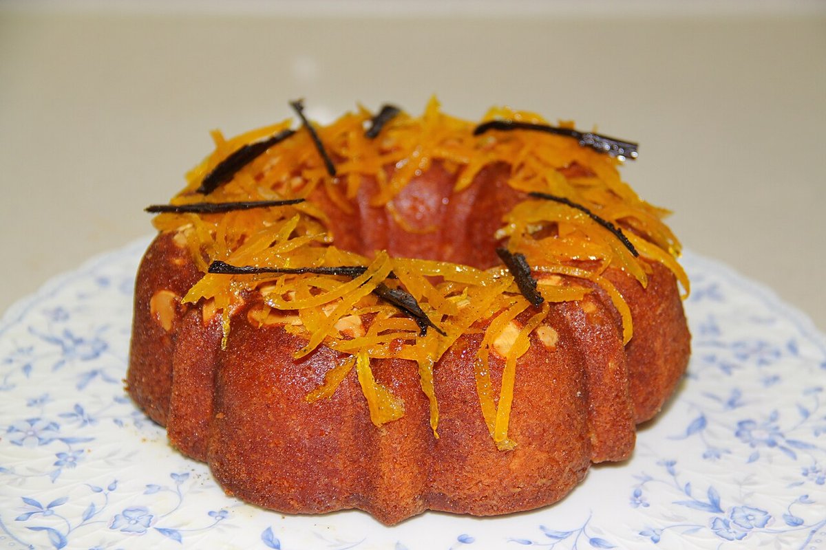 Bolo de laranja em forma de anel com calda e raspas de laranja