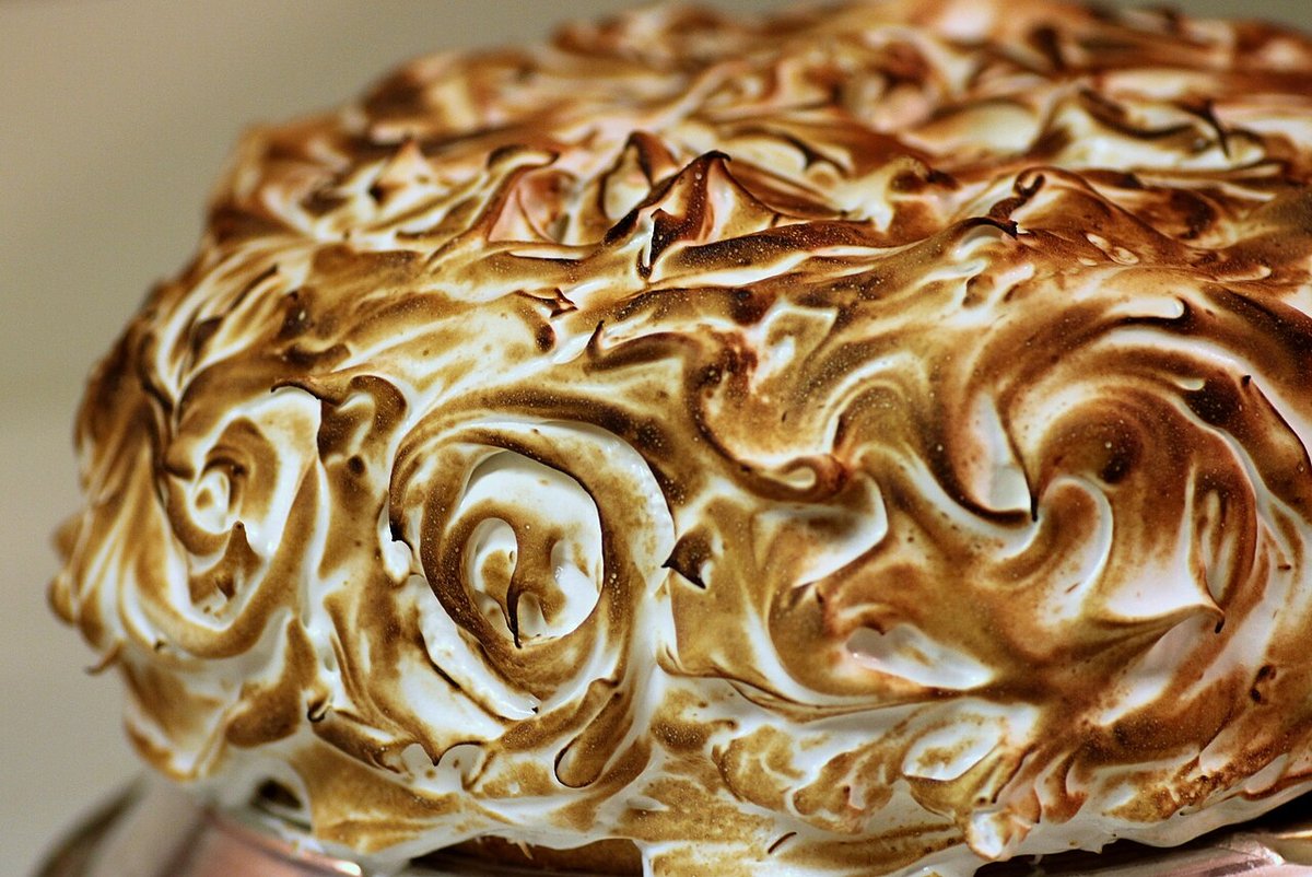 Bolo coberto com merengue maçaricado em espirais douradas