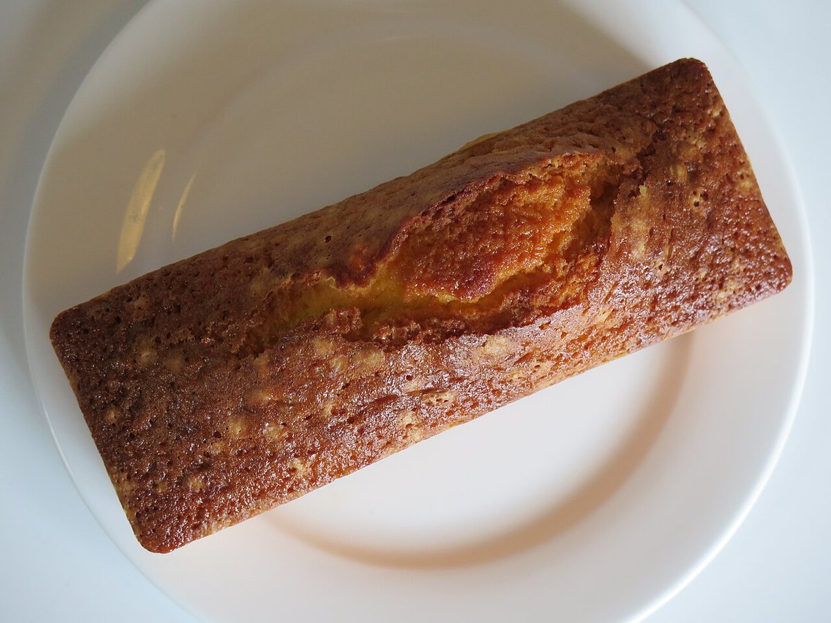 Bolo de manteiga dourado assado em forma de bolo inglês sobre prato branco