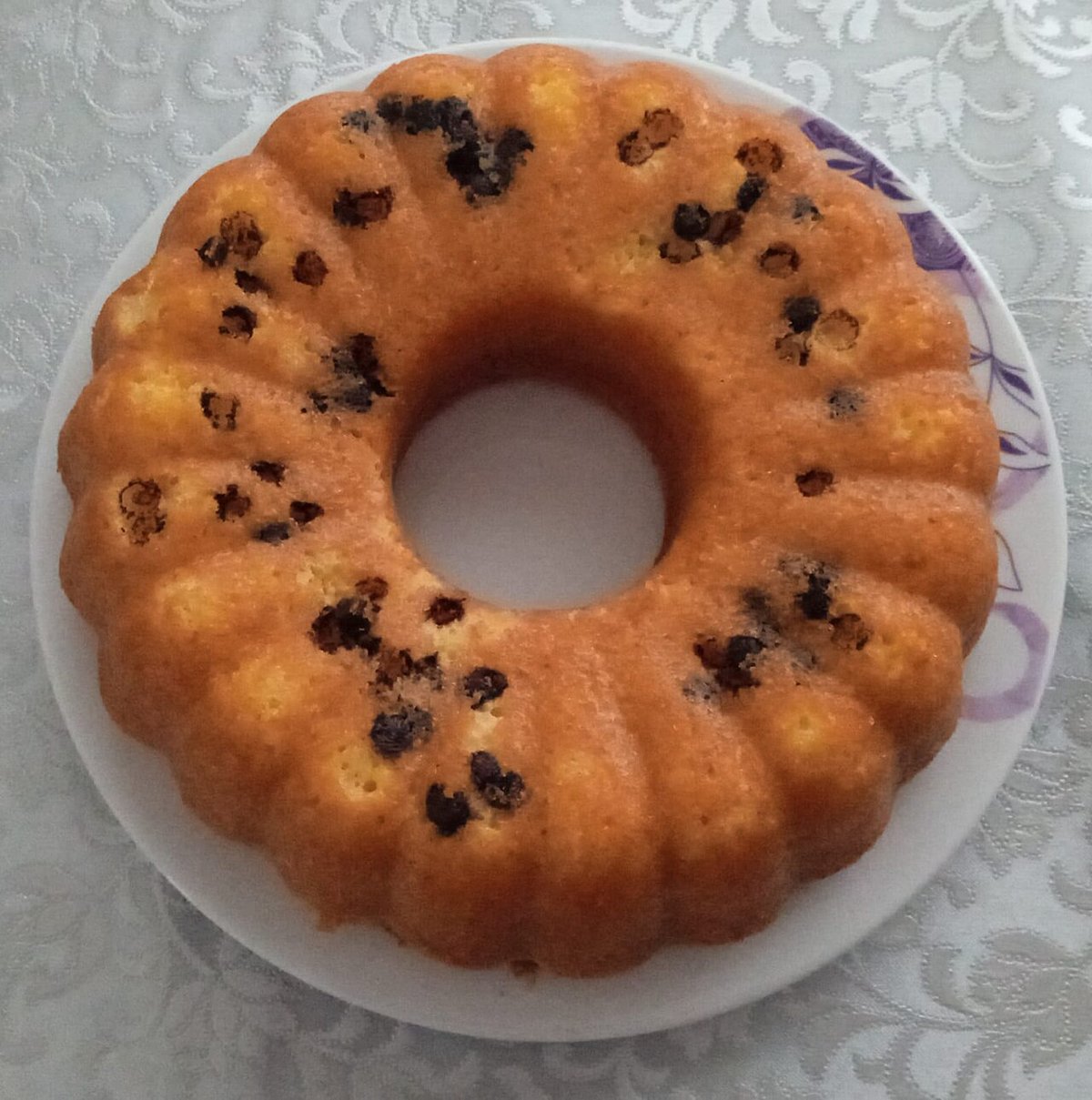 Bolo amarelo em forma de anel com pedacinhos de chocolate na massa